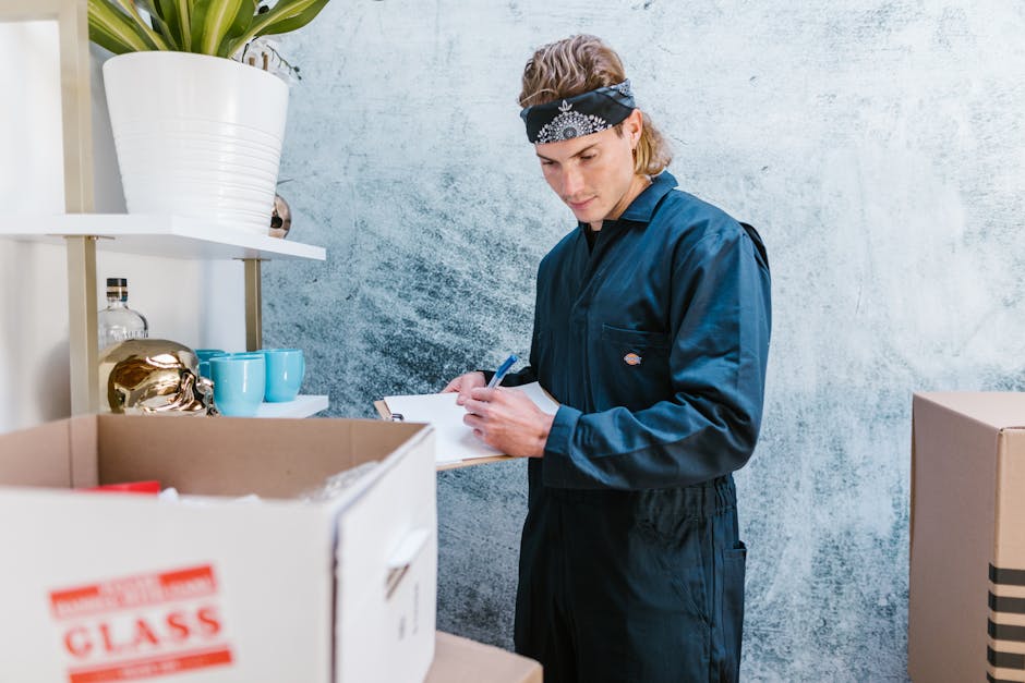 A person wearing a white t-shirt and blue jeans is seen placing a wrapped antique item into a cardboard box during a furniture transport and packing process in a residential setting. The item is secur